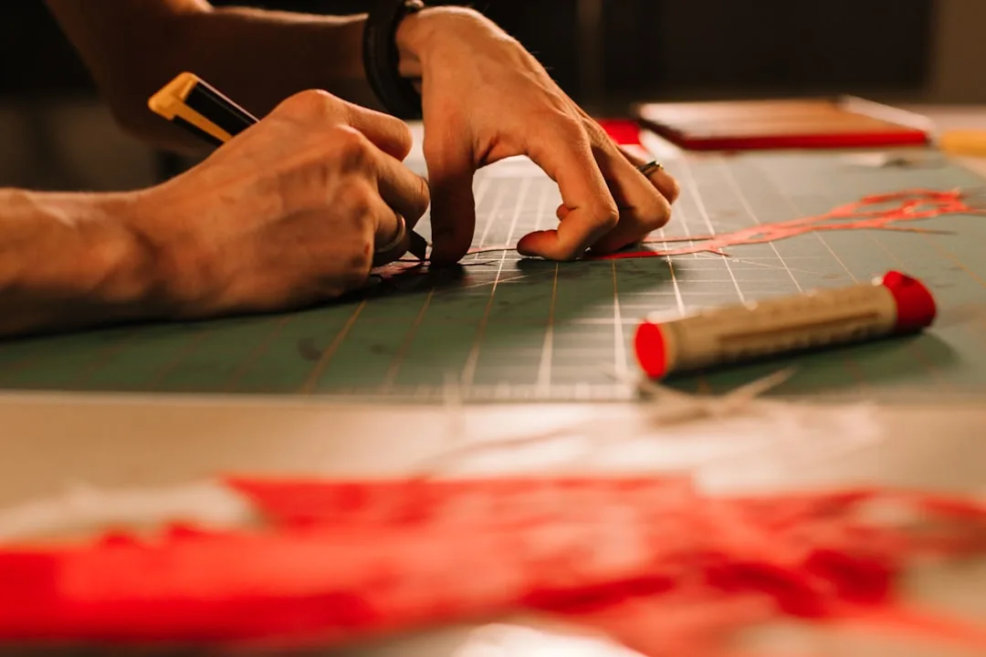 Master tailor cutting red fabric with precision